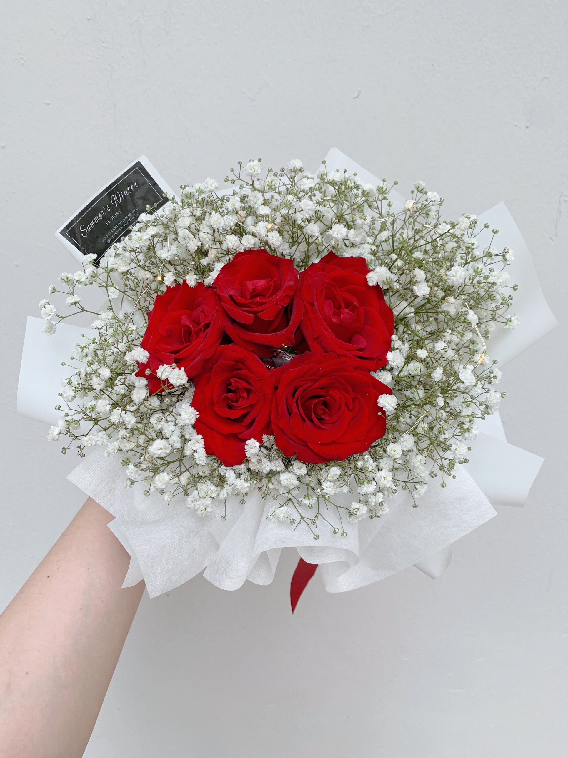 Fresh Baby Breath and Fresh Red Roses with white wrapping paper